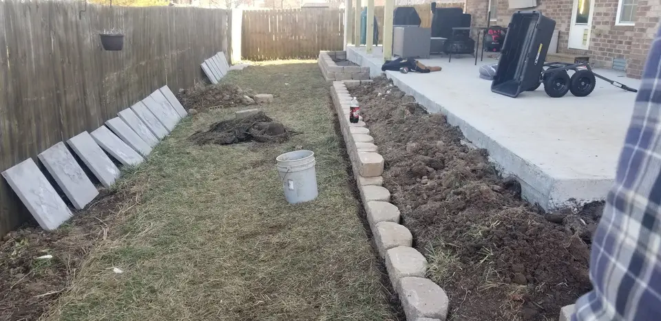 Block edging being installed along a new landscape bed, recent work by L&M Lawncare
