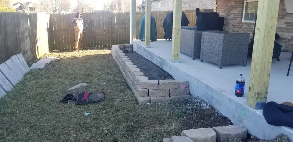 Raised block bed along a patio and pergola, recent work by L&M Lawncare