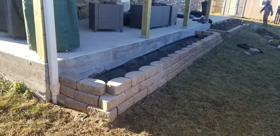 Block bed with fresh mulch along a patio, recent work by L&M Lawncare