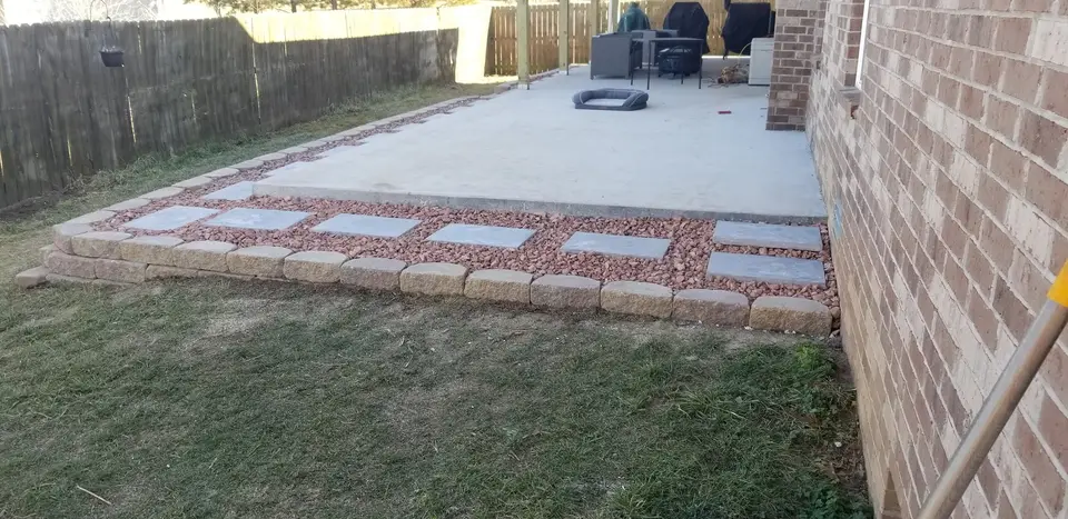 Paver patio border beside a brick house, recent work by L&M Lawncare