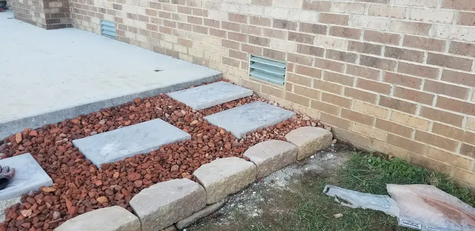 Stepping pavers in red mulch along a brick house, recent work by L&M Lawncare